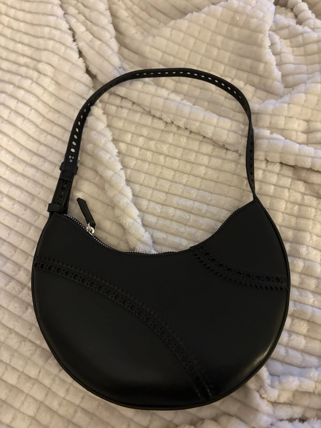 Svart axelväska i skinn med håldetaljer - 1