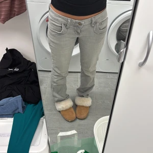 Grå bootcut LTB jeans - Snygga grå jeans med bootcut passform och klassiska fem fickor. Jeansen har broderade bakfickor och detaljerade sömmar. Tillverkade i mjukt jeanstyg med låg midja och dragkedja framtill. Perfekta för en avslappnad och trendig look. Storlek 27/30