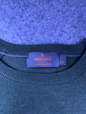 Morris Stickad tröja  - Exklusiv Morris stickad merinoullströja i snygg grön färg. Tunn, mjuk och lyxig kvalitet — perfekt för preppy/old money-stil.  Skick: ✔ Mycket bra skick ✔ Mjuk merinoull ✔ Inga hål eller fläckar  Detaljer: • Storlek: XS • Passar även slim S • Material: 100% Merino Wool • Färg: Grön