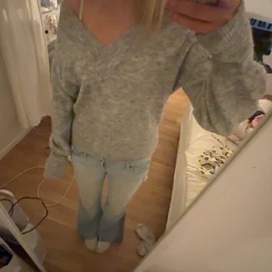 Grå v-ringad stickad tröja Bik Bok - Mysig grå stickad tröja från Bik Bok i ullblandning. Tröjan har v-ringad hals och långa ärmar med lite loose passform. Perfekt för att hålla sig varm och ändå se chill ut. Passar dig som gillar enkel och stilren look.