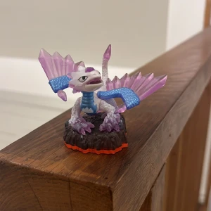 Skylanders figur - flashwing - Skylanders flashwing figur i fint skick, med lila och blå detaljer samt genomskinliga vingar. Perfekt till samlingen eller för att spela Skylanders. Inga synliga skador eller slitage, färgerna är klara och basen hel.