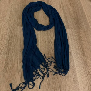 Mörkblå halsduk med fransar - En snygg mörkblå halsduk med fransar i ändarna. Den är lätt och luftig, men skyddar ändå mot kyla. Perfekt nu till hösten och vintern💗 Halsduken är ungefär 2m lång. Skriv gärna om du har frågor och läs min bio innan du köperrr🫶🏻 Kan diskutera priset. Säljer även en likadan fast vit!