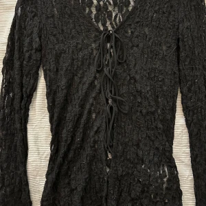 Svart spetsblus med snörning Gina Tricot - Svart långärmad spetsblus från Gina Tricot med snygg snörning framtill. Blusen har v-ringning och är helt i genombruten spets. Perfekt för dig som vill ha en edgy och trendig look. Pris kan diskuteras! 