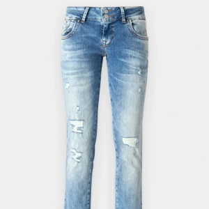 Blå slitna jeans - Säljer ett par blå jeans med slitningar och hål vid knäna i storlek 25/32 från LTB! Jeansen har raka ben men jag har sytt om de till bootcut! De är lågmidjade. Materialet är jeans med snygg tvättad look och ljusare partier framtill. Perfekt för dig som gillar en avslappnad och trendig stil.