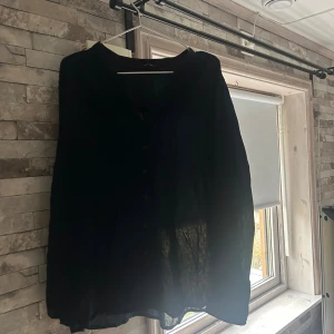 Mörkblå henley från Lindex Generous - Snygg mörkblå henley-skjorta från Lindex Generous i storlek 50. Skjortan har v-ringad hals, knappar framtill och diskreta söm-detaljer längs bröstet. Materialet är lätt och känns luftigt, perfekt för dig som gillar enkel och stilren design.