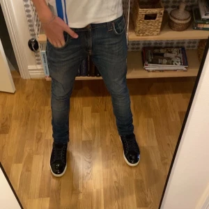 Blå Nudie denim jeans - Tja, säljer nu ett par riktigt feta Nudie Jeans som är Modellen : Denim (Slimfit),   📏 Längd: 104 cm 📏 Bredd: 41 cm Kvalitet rakt igenom – sitter snyggt och funkar till allt, oavsett stil. 💬 Skriv vid minsta fundering, fler bilder eller info fixas direkt! 💸 Priset är inte hugget i sten, så kom med ett rimligt bud – först till kvarn gäller! 🙌😎.                             Storleken är W29 L32