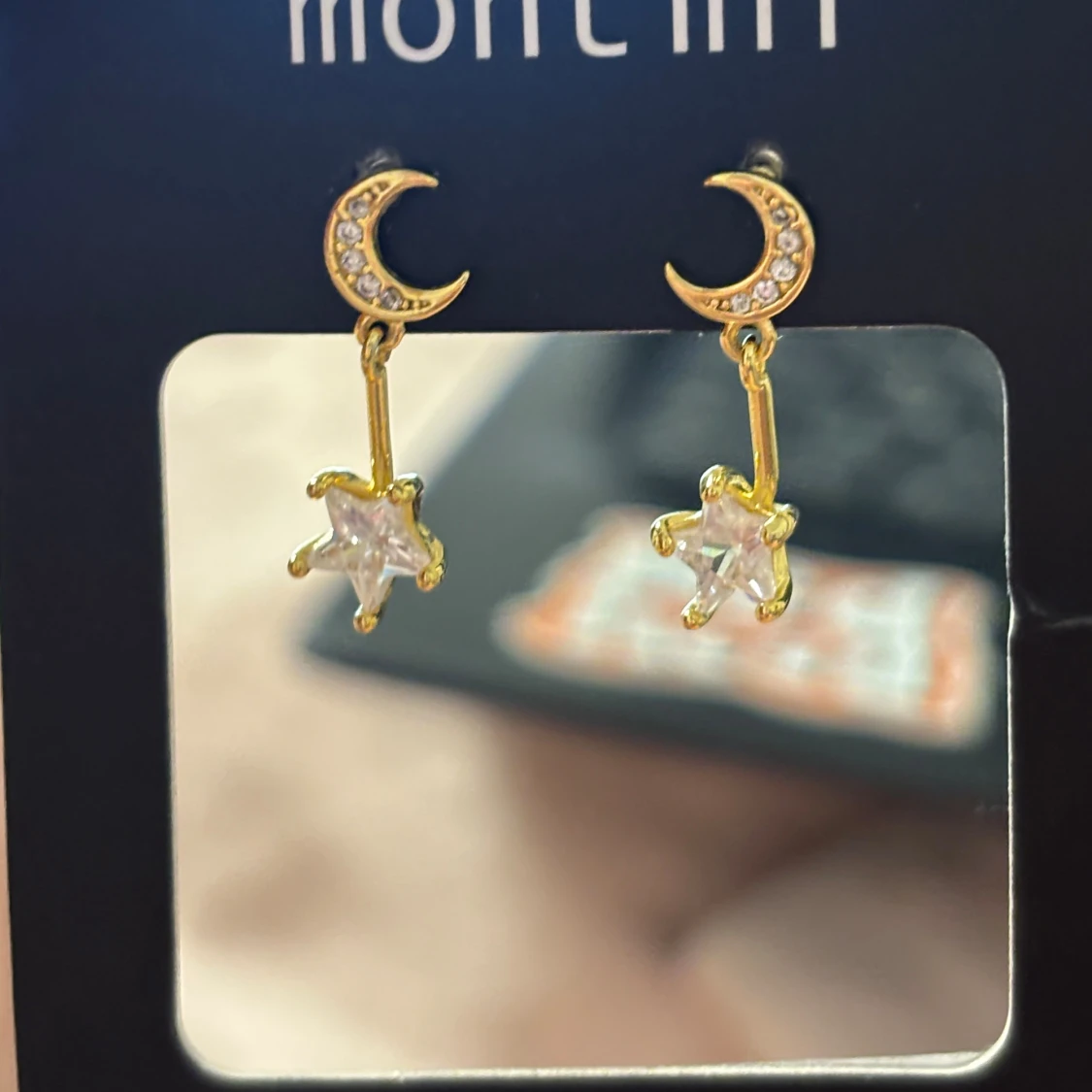 Guldiga örhängen med måne och stjärna