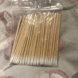 Sminkapplikatorer i trä 50-pack - Ett paket med ca 50 sminkapplikatorer med trähandtag och vita spetsar av bomull. Perfekta för att fixa detaljer, sudda eyeliner eller applicera ögonskugga med precision. Kommer i en praktisk zip-påse.