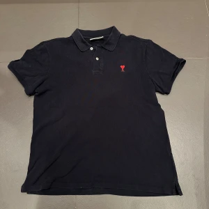 Piké - Mörkblå piké ifrån Ami Paris i mycket bra skick! Kan ha tappat en aning färg men inget mer än det som syns på bilden! 