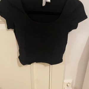 Svart croppad topp från H&M  - svart lite kortare t-shirt från h&m. använd men i fint skick. storlek: s/36
