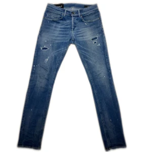 Blå Dondup jeans - Dessa Dondup jeans är i mycket exemplariskt skick och har inga tecken på användning och är sparsamt använda. Det är deras mest sålda George modell i storlek 31 med några slitningar som visas på bilderna. Nypris på dessa är 3600kr. Hör av dig vid minsta fundering.