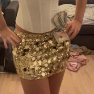 Guldig paljettkjol med stora paljetter - Superglittrig kort kjol i guld med stora paljetter som verkligen fångar ljuset. Kjolen har en tight passform. Endast använd en gång💓