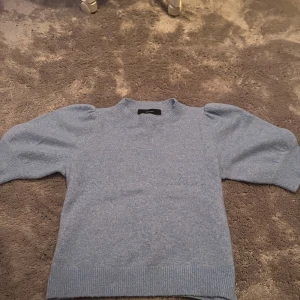 Ljusblå stickad tröja Vero Moda - Superfin ljusblå stickad tröja från Vero Moda med puffade kortärmar och ribbade muddar. Den är nästan aldrig använd. Otroligt skön. Tröjan har en rund halsringning och är gjord i mjukt material som känns skönt mot huden.💓💓 Det är bara att höra av sig om man har prisförslag, frågor eller vill ha fler bilder på tröjan.🩷
