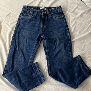 Blå jeans från fsbn, rak modell - Klassiska blå jeans från fsbn i rak passform. Jeansen har fem fickor, bälteshällor och snygga kontrastsömmar. Tillverkade i slitstarkt denim med en mörkblå tvätt. Perfekta för dig som gillar en enkel och tidlös stil.