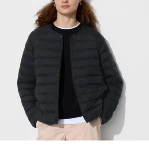 Uniqlo jacka - Snygg svart pufferjacka med rund halsringning och knäppning framtill. Jackan har en quiltad design och är lätt vadderad, perfekt för kyligare dagar. Enkel och stilren modell som passar till det mesta.