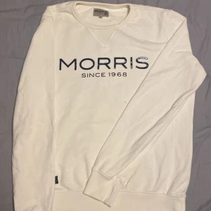 Vit Morris Tröja - Jag säljer en vit Morris tröja. Med en text på framsidan, Tröjan är väldigt skön men har en synlig fläck på framsidan.