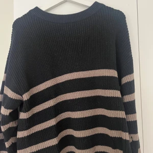 Randig stickad tröja Bondelid - Mysig stickad tröja från Bondelid i svart med breda beige ränder. Sparsamt använd!