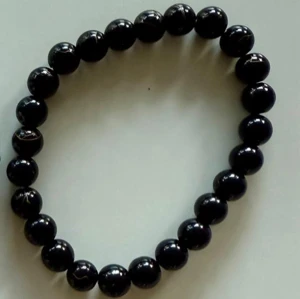 Två pärlarmband i svart och vitt - Säljer två stilrena armband med pärlor – ett helsvart och ett vitt med grå marmorering och en liten silverfärgad hantel som detalj. Perfekta accessoarer för att lyfta din outfit med en cool och modern touch.