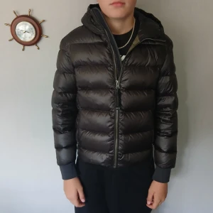 Svart dunjacka Parajumpers  - Säljer en svart dunjacka från Parajumpers  och ribbade muddar. Jackan har en klassisk pufferlook, dragkedja framtill och snyggt PJS-märke på ärmen. Perfekt för kalla dagar och riktigt skön att bära.