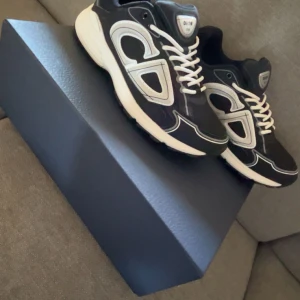 Svarta Dior B30 - Svarta Dior B30 med vita snören. Kommer i originalkartong, dustbag och extra skosnören.  Priset är inte fasthugget.