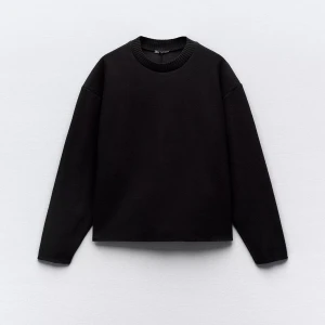 Svart långärmad tröja från Zara - En stilren svart långärmad tröja från Zara med rund halsringning och ribbad kant. Tröjan har en loose passform och är tillverkad i mjukt material som passar perfekt till lager-på-lager under höst och vinter.