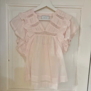 Ljusrosa blus med volang från Neo Noir - Supersöt & helt osnvänd ljusrosa blus från Neo Noir med volangdetaljer och spetsinslag.  Storlek 34💗