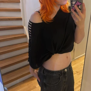 Svart topp  - Svart croppad topp från Rut&Circle med coola öppna axlar och banddetaljer längs ärmarna. Köpt second hand men har själv aldrig använt den:)