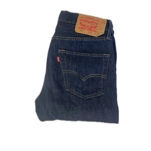 Levi's 501 mörkblå jeans straight fit - Klassiska Levi's 501 jeans i mörkblå denim med raka ben och normal passform. Använda endast ett fåtal gånger.