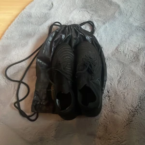 Nike phantom elite - Säljer ett par svarta Nike phantom gx elite, helt oanvända fotbollsskor i storlek 45. Perfekt för dig som vill  ta ditt spel till nästa nivå. Kontakta mig om ni har några funderingar! Tillkommer även en svart Nike påse  