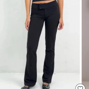 Svarta Lågmidjade bootcut kostymbyxor från Nelly  - Svarta bootcut-byxor från Nelly i modellen Soft Flare Pants. Byxorna har låg midja och är tillverkade i ett mjukt, stretchigt material som sitter skönt. Snygg passform med utsvängda ben och enkel design som funkar till många olika stilar.