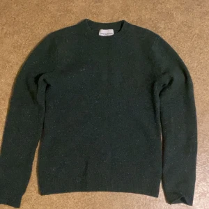 Mörkgrön stickad tröja These Glory Days - Mysig mörkgrön stickad tröja från These Glory Days. Klassisk rund halsringning och långärmad modell, perfekt för kyliga dagar. Enkel och stilren design som funkar till det mesta. Materialet känns mjukt och värmande.