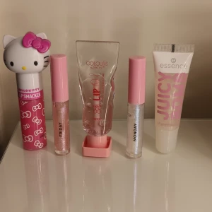 Sött kit med läppglans - Fem läpprodukter: Hello Kitty Lip gloss med rosa design, två glittriga läppglans med rosa och silvriga toner, Technic Lip Oil Cherry och Essence Juicy Bomb Shiny Lip Gloss. Några av dom är testade.