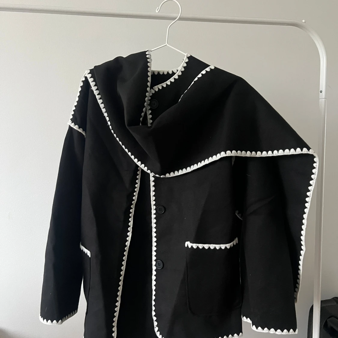 Svart jacka med vit broderad kant