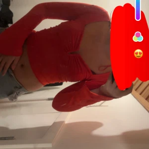 Röd croppad långärmad topp - Snygg röd croppad topp med lång ärm och v-ringad urringning framtill. Toppens material är stretchigt och sitter tight mot kroppen, perfekt för att skapa en trendig look. Passar dig som gillar att sticka ut med färg och form.