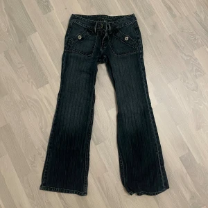 Mörkblå lågmidjade bootcut jeans  - Snygga mörkblå lågmidjade bootcut jeans med från Banana Republic med diskret randigt mönster. Coola fickor där fram o bak. Köpte i Köpenhamn för 750 för några månader sen men säljer då de har blivit småa och lite för korta på mig som är 168cm. Hade passat 165 och under.