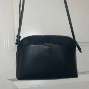 Axelremsväska med guld detaljer  - Använd axelremsväska men fortfarande i bra skick. 