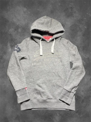 Superdry hoodie - En fet super dry hoodie som sitter slim fit. Det står att den är i s men den är slim fit modell så sitter mer som xs.