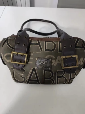 D&G brun handväska med logotyp - Cool handväska från Dolce & Gabbana i brun canvas med stora logotyper och detaljer i mörkbrunt skinn. 