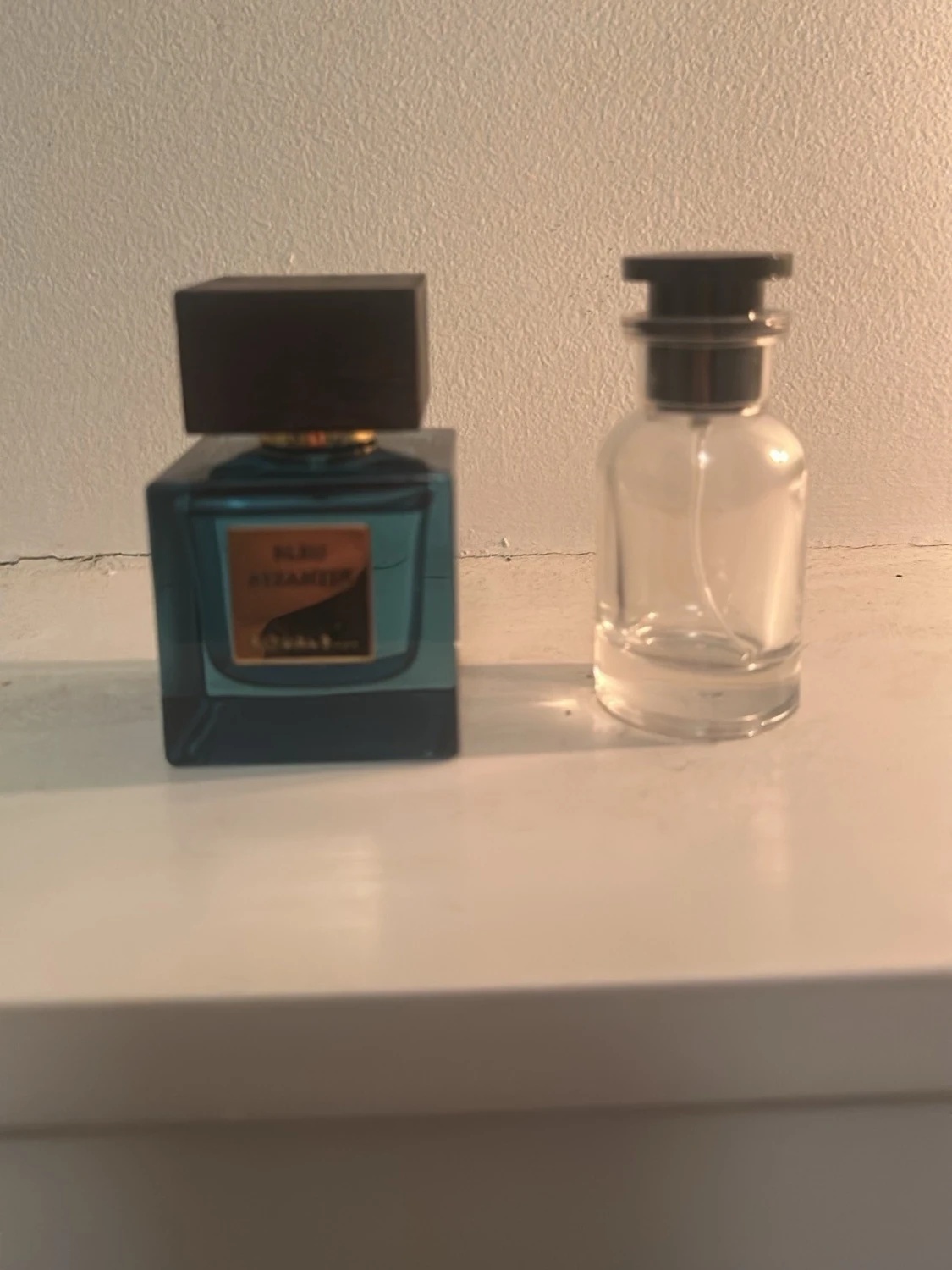 Blå parfymflaska med svart lock rituals 