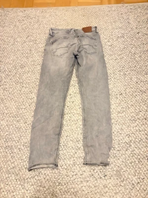 Grå jeans från Blue Ridge - Snygga ljusgrå jeans från Blue Ridge med klassisk femficksdesign och raka ben. Jeansen har bälteshällor och knappgylf. Perfekta för dig som gillar en enkel och stilren look.