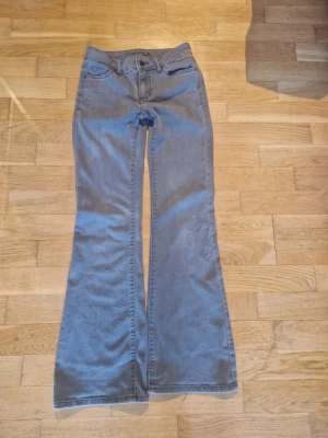 Blå bootcut jeans med utsvängda ben - Snygga grå jeans med bootcut och utsvängda ben. Klassisk femficksmodell med normal passform. Den är nya men säljer för att dem va korta på mig