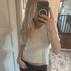 Vit ribbad topp - Säljer en vit ribbad croppad topp med korta ärmar och rund hals.