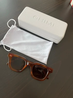 Bruna CHIMI solglasögon i retrostil - Snygga solglasögon från CHIMI med brunmelerat, fyrkantigt acetatbåge och bruna tonade glas. Kommer med originalfodral och putsduk. Perfekt accessoar för en trendig look.