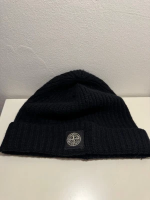 Stone Island Mössa - Riktigt schyst Stone Island Mössa, köpt på NK i Göteborg för 1 149 kr, skick 8-10, bild på användning (bild 3). Finns ett lagat hål men syns inte det minsta vid användning, PM för mer information! Kan gå ner i pris vid snabb affär! 🌟