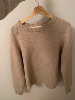 Beige kashmir tröja - Mysig beige stickad tröja med rund halsringning och ribbade muddar vid ärmslut och nederkant. Tröjan har en avslappnad passform och är tillverkad i ett mjukt material som känns skönt mot huden. Perfekt för kyliga dagar. Väldigt lik ”soft goat boyfriend crewneck”💓