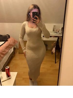  beige ribbad långklänning - Säljer en beige ribbad långklänning med lång ärm och rundad halsringning. Klänningen är figurnära och har en snygg stretchig passform som framhäver formerna. Materialet är stickat och mjukt, perfekt för dig som gillar stilrena och enkla plagg. Aldrig använd. Är en xs men passar nog s och M också extremt stretchig. Nypris 349kr
