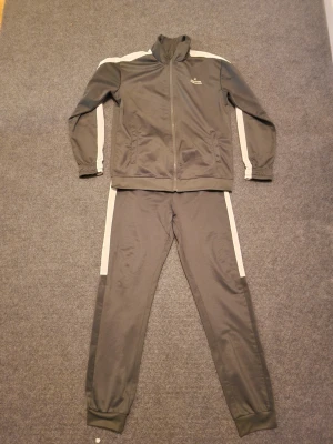 Pyjamas  - Grått träningsset med jacka och byxor. För barn mellan 10-12 år. 