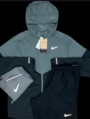 Ingen sko syns på bilden - Bilden visar en Nike-jacka och byxor, men inga skor finns med. Kan därför inte ge någon skobeskrivning.