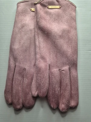 Rosa mocka handskar  - Bilderna visar ett par rosa mockahandskar med mjuk yta och metallfärgade detaljer upptill. Dessa har även touch möjlighet på pekfingret då de menas att du slipper ta av dig handsken när du behöver svara på mobilen. 