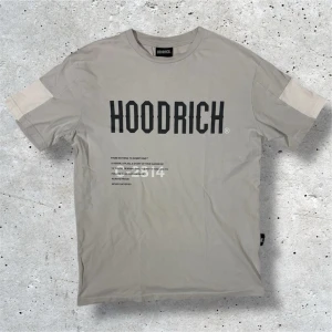 Hoodrich T-Shirt - Säljer denna beige/grå Hoodrich T-Shirten i stl XS. Tröjan är i väldigt bra skick utan några som helst tecken på användning. Hör av er vid frågor, pris kan diskuteras vid snabb affär!